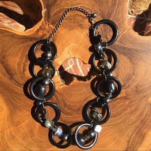 Chunky black and silver circular rings with beads of grey hues, flashy and bold